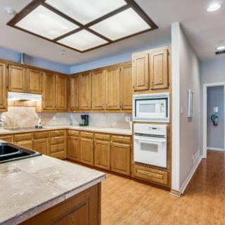 A modern kitchen with wooden cabinets and built-in appliances.