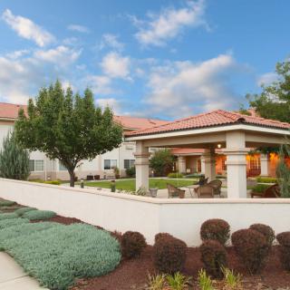 A beautiful home with a well-maintained garden and clear blue sky.