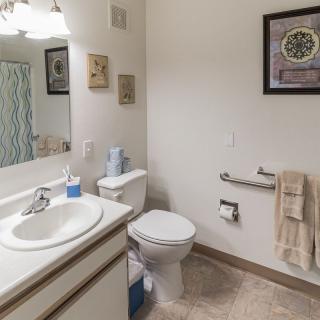 A clean and organized bathroom with a sink, toilet, and shower curtain.