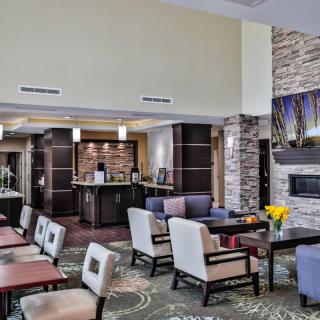 A modern hotel lobby with comfortable seating and a fireplace.