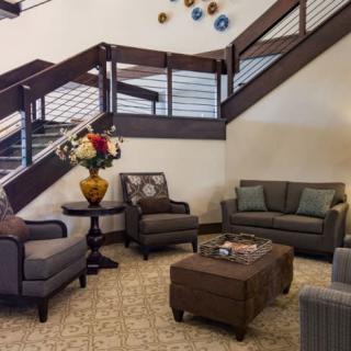 A cozy lobby with comfortable seating and a modern staircase.