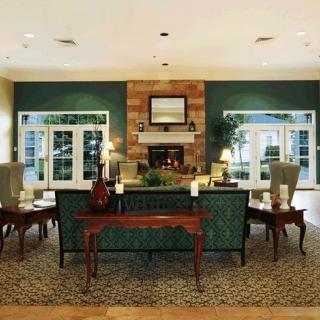 A stylish living room featuring a cozy fireplace, elegant furniture, and large windows allowing natural light to fill the space.