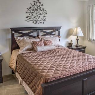 A cozy bedroom with a neatly made bed and stylish decor.