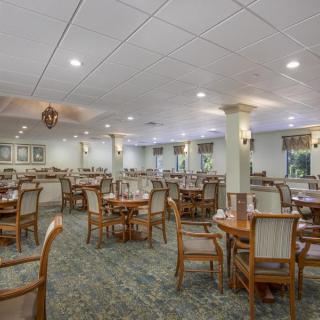 A spacious and elegantly designed empty dining room with tables and chairs arranged neatly.