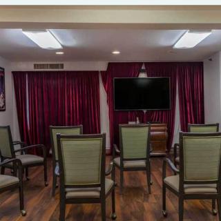 A small conference room with chairs arranged in rows facing a television.