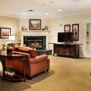 A cozy living room with a fireplace, sofa, and television.