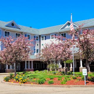 A beautiful residential building surrounded by blooming flowers and clear blue skies.