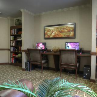 A cozy office space featuring two computer workstations and a bookshelf.