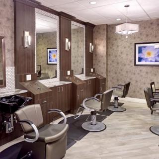 A modern hair salon with styling stations and comfortable chairs.
