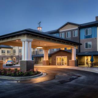 A nighttime view of a well-lit hotel entrance with modern architecture.
