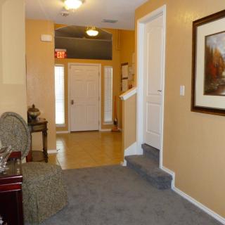 A cozy hallway featuring a staircase, seating area, and wall art.