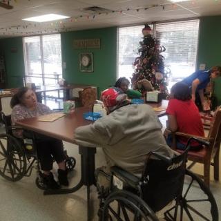 Residents engaging in an activity together in a care facility during the holiday season.
