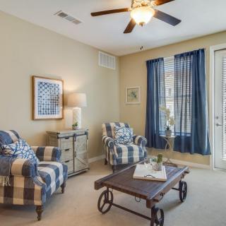 A cozy living room with plaid armchairs, a rustic coffee table, and navy curtains.