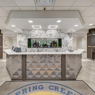 A modern hotel lobby featuring a stylish marble reception desk.
