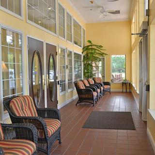 A cozy waiting area with wicker chairs and large windows.