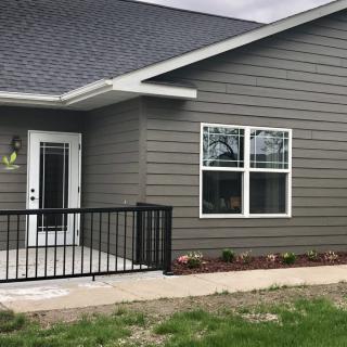 A modern house exterior with a porch and large windows.