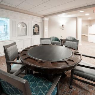 A cozy dining area featuring a round wooden table and upholstered chairs.