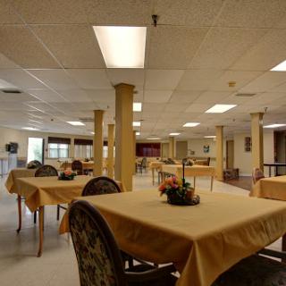 A spacious and well-lit dining hall featuring neatly arranged tables and chairs.