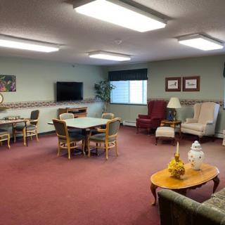 A cozy lounge area with comfortable seating, tables, and a television.