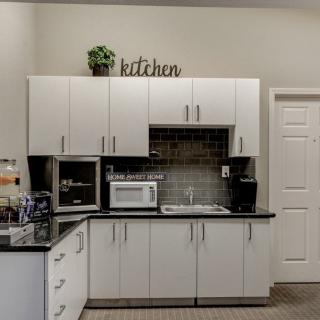 Modern kitchen setup with white cabinets, a microwave, and a coffee maker on the countertop.