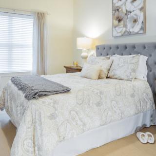 A cozy and neatly arranged bedroom with a comfortable bed and elegant decor.