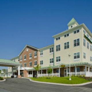 A modern healthcare facility with a multi-story building and a clear blue sky backdrop.