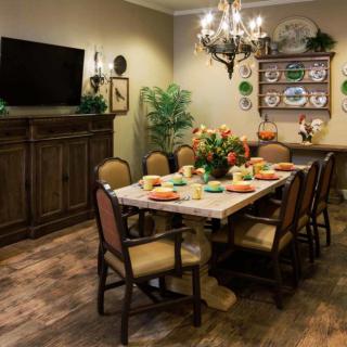 A cozy dining room with a set table, wooden furniture, and decorative elements.