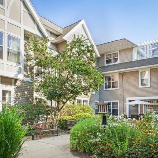 A peaceful courtyard surrounded by residential buildings with lush greenery.