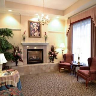 A cozy living room featuring a fireplace, two armchairs, and elegant decor.