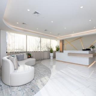 A sleek and modern office reception area featuring minimalist design with bright lighting and elegant furnishings.