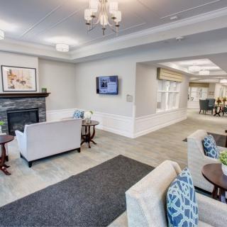 A modern living room with elegant furnishings, featuring a fireplace, television, and comfortable sofas.