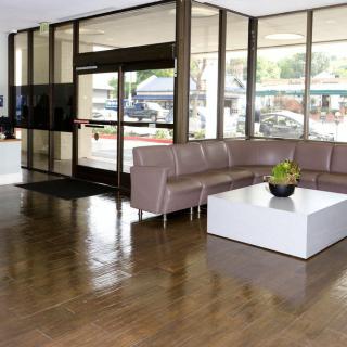 A modern lobby with a sleek sofa and table arrangement near glass doors.