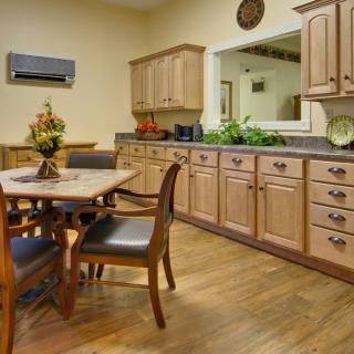 A cozy kitchen and dining area with wooden cabinets and a dining table set.