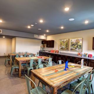 A modern dining area with colorful wooden tables and artwork on the walls.