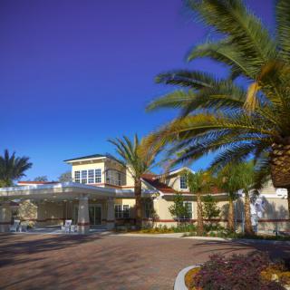 A scenic view of a building surrounded by palm trees under a clear blue sky.