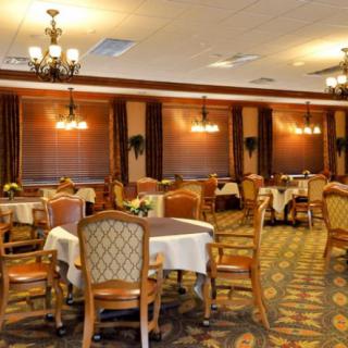 An elegant dining room with neatly arranged tables and chairs, featuring classic decor and soft lighting.