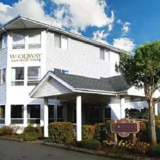 The exterior of a hotel with prominent signage and surrounding greenery.