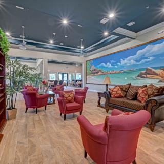 A cozy and modern living room featuring vibrant seating and a large mural.