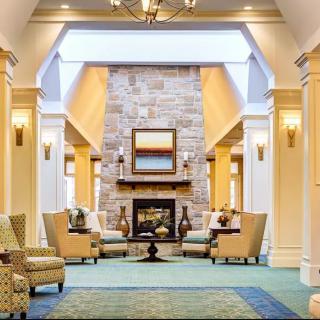A cozy lounge with a central fireplace, surrounded by comfortable seating.