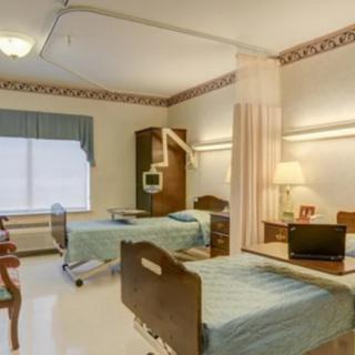 A well-organized hospital room with two patient beds and a curtain divider.