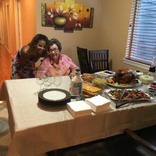 A warm family gathering around a dinner table filled with delicious food.