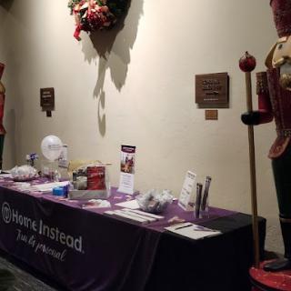 A decorated exhibition table showcasing promotional materials next to a nutcracker figure.