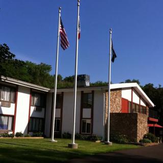 A hotel building with three flags in front of it on a sunny day.