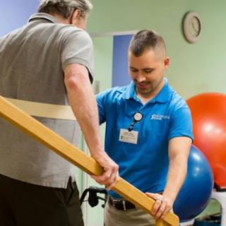 A therapist assists a patient with rehabilitation exercises in a healthcare setting.