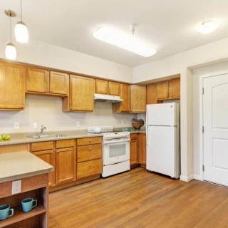 A modern kitchen with wooden cabinets and standard appliances.