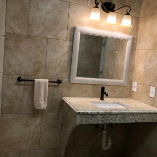 A modern bathroom with a stylish sink and well-lit mirror.