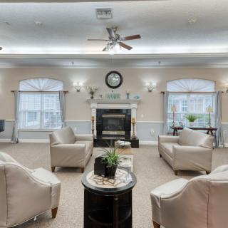 A cozy living room with stylish chairs and a central fireplace.