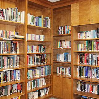 A cozy corner of a library with wooden bookshelves filled with books.