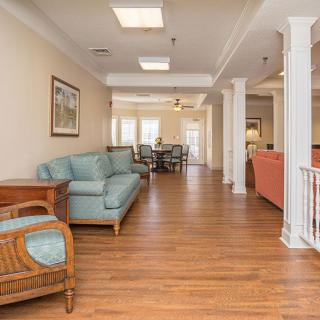 Spacious living area with hardwood flooring, comfortable seating, and classic interior design elements.