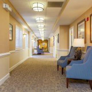 A well-lit hallway with comfortable chairs and decorative artwork.